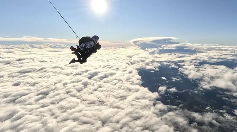 Saut en tandem au-dessus de la mer de nuages