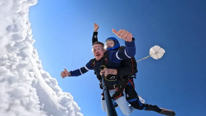 Saut en tandem dans les nuages pouce leve